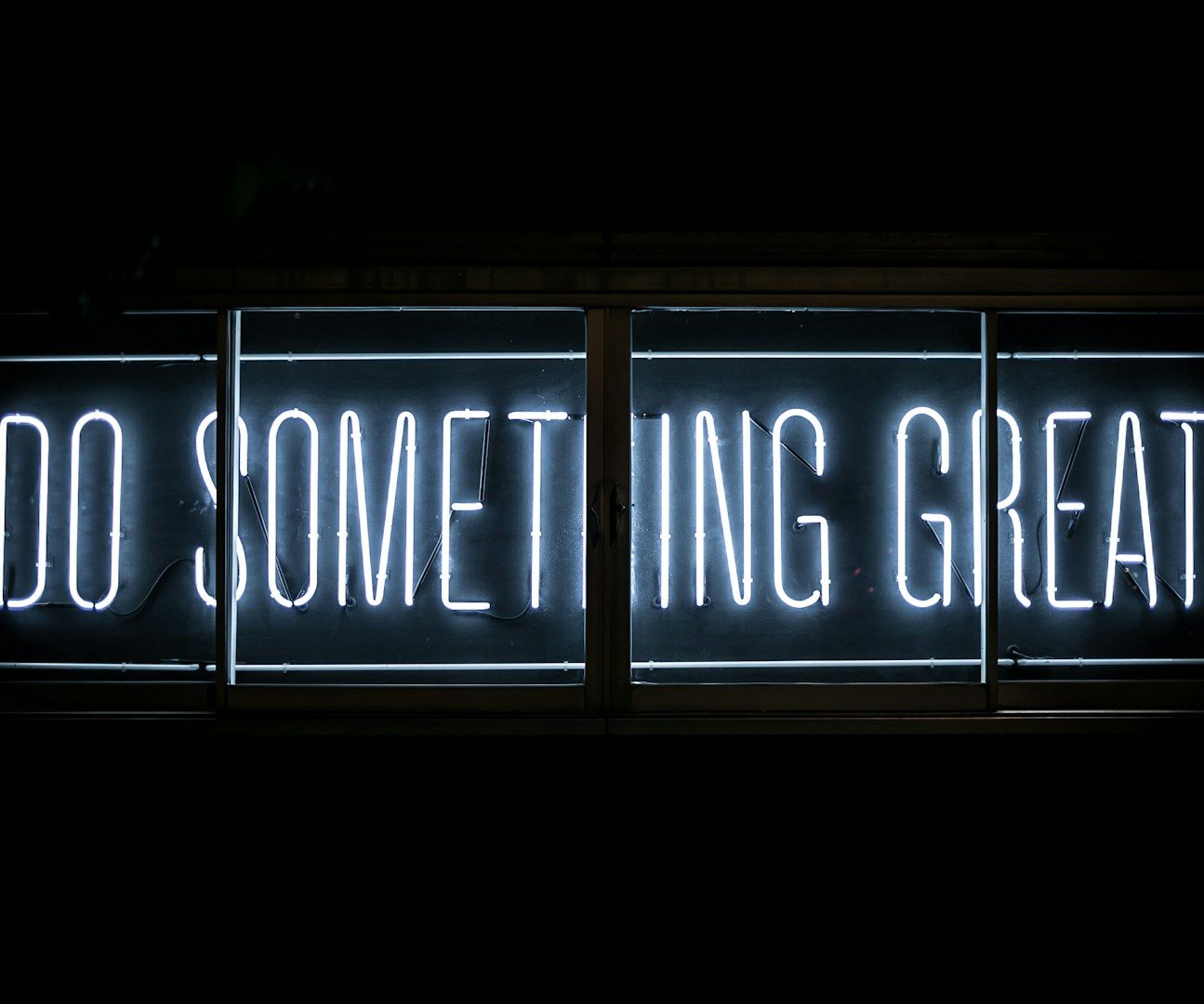 Neon-Schild mit der Aufschrift "Do Something Great" in leuchtenden Buchstaben.